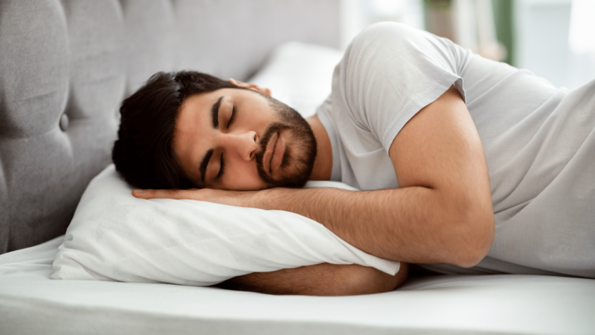 Image of man sleeping in a bed on a pillow
