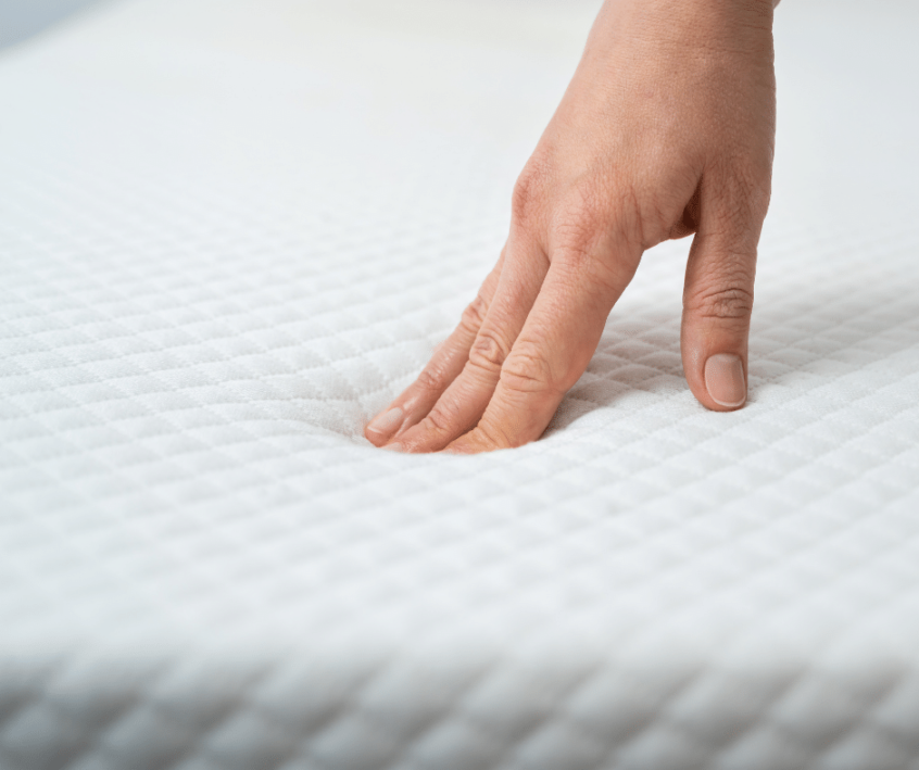 Image of hand pressing into a mattress